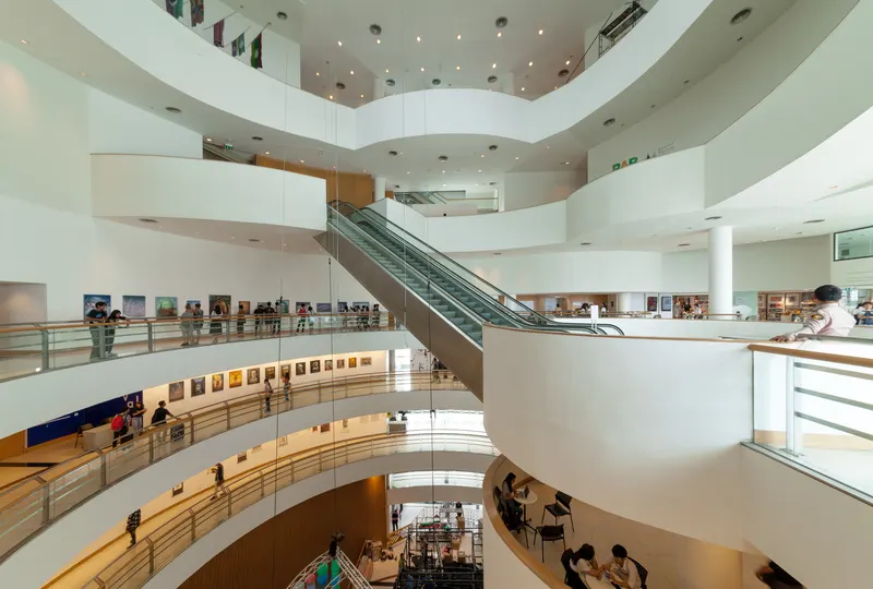 Curving white interior walkway inside Bangkok Art and Culture Centre