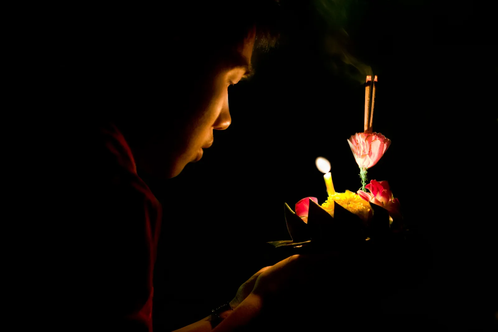 Lit krathongs floating on water during Loy Krathong in Bangkok