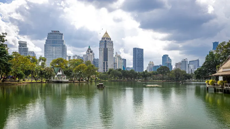 Lumphini Park lake with Bangkok towers behind it